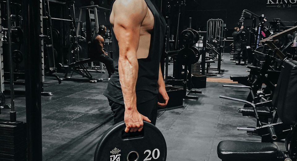 Athlete carrying a weight plate in a gym
